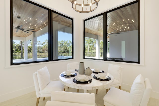 dining space with hardwood / wood-style floors and ceiling fan with notable chandelier