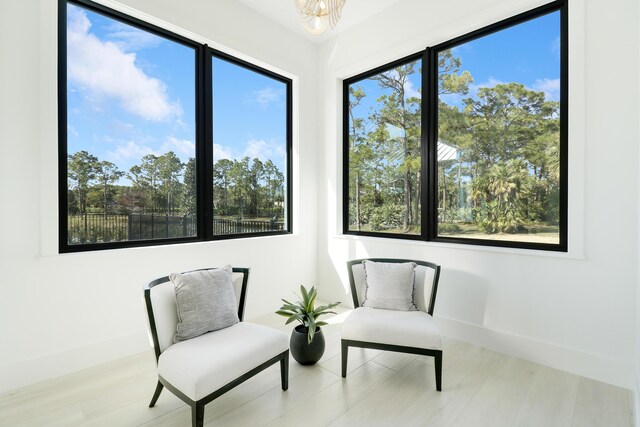 sitting room featuring plenty of natural light, a chandelier, and light hardwood / wood-style floors