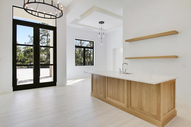 interior space with a notable chandelier, sink, french doors, and decorative light fixtures