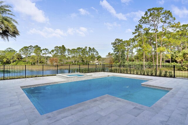 view of pool featuring a patio area, a water view, and an in ground hot tub