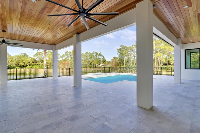 view of pool with ceiling fan, a water view, and a patio area