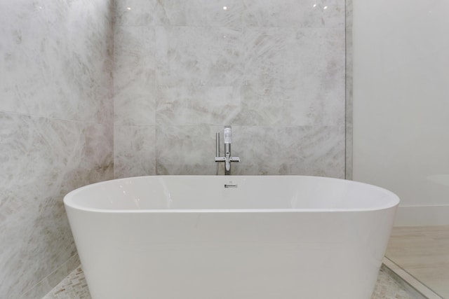 bathroom featuring tile walls and a tub to relax in