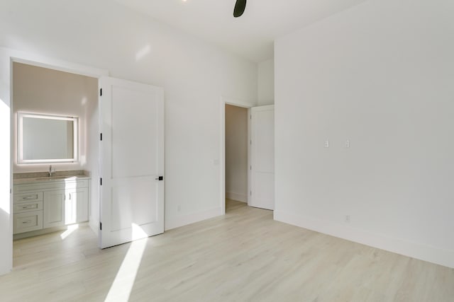 unfurnished bedroom with sink, light hardwood / wood-style flooring, ceiling fan, and ensuite bathroom