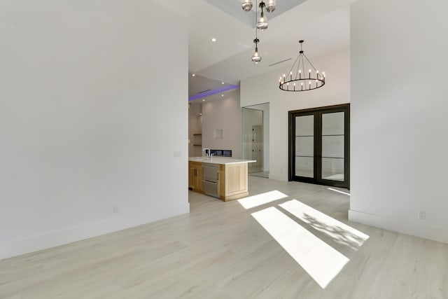 interior space featuring light hardwood / wood-style floors, french doors, and a chandelier