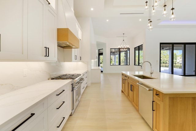 kitchen with appliances with stainless steel finishes, pendant lighting, white cabinetry, and a spacious island