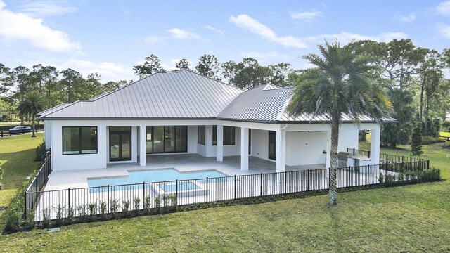 rear view of property with a fenced in pool, a patio area, area for grilling, and a yard