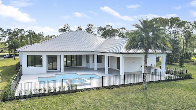 rear view of house with a fenced in pool, a yard, a patio area, and exterior kitchen