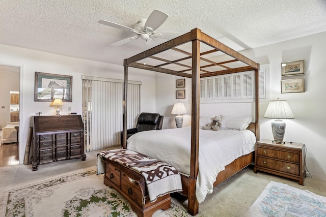 carpeted bedroom featuring a ceiling fan and a textured ceiling