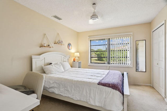 carpeted bedroom featuring a textured ceiling and a closet