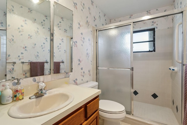 full bath featuring a stall shower, vanity, toilet, and wallpapered walls