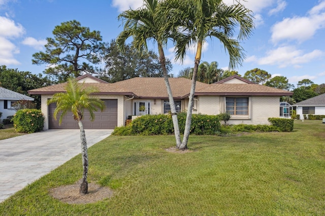 ranch-style house featuring a front yard, brick siding, driveway, and an attached garage