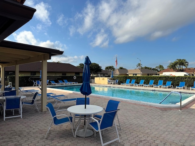 community pool featuring a patio and fence