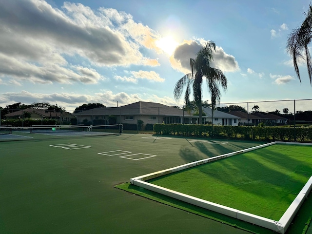 view of community with a tennis court, a residential view, and fence