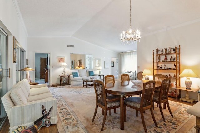 dining space with a chandelier, lofted ceiling, visible vents, light wood-type flooring, and crown molding