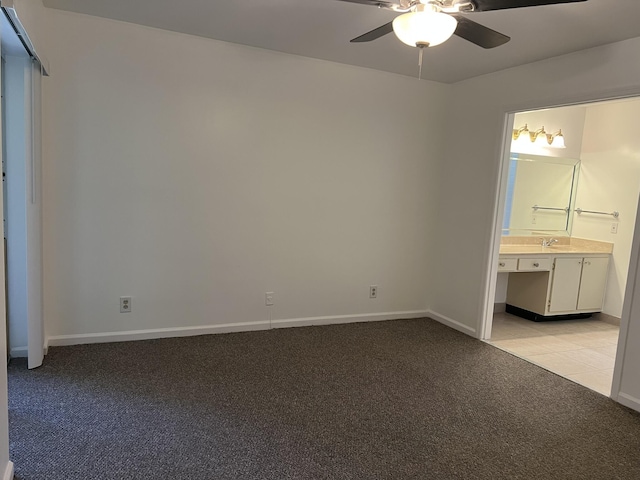 unfurnished bedroom with ensuite bath, ceiling fan, sink, and light colored carpet