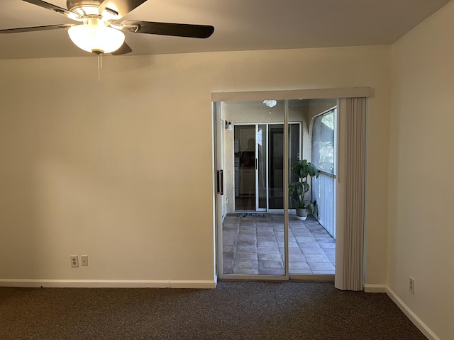 unfurnished room featuring ceiling fan and dark carpet