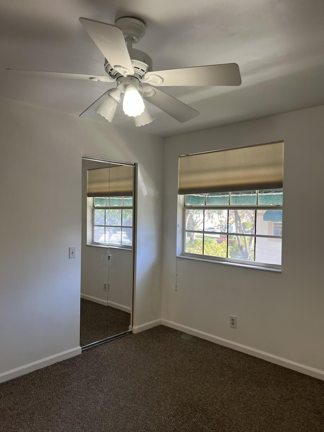 carpeted spare room featuring ceiling fan