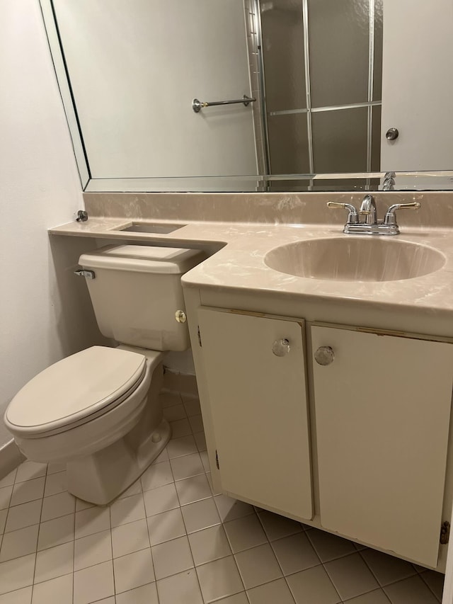 bathroom featuring toilet, vanity, and tile patterned floors