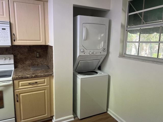 laundry area with dark wood-type flooring and stacked washer and clothes dryer