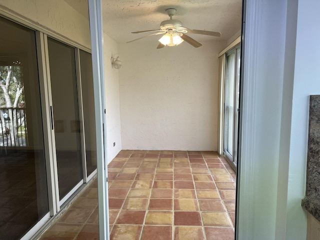 unfurnished sunroom featuring ceiling fan