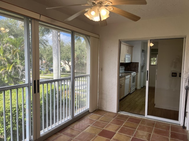 unfurnished sunroom with ceiling fan