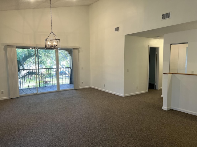 unfurnished room with high vaulted ceiling, dark carpet, and a notable chandelier