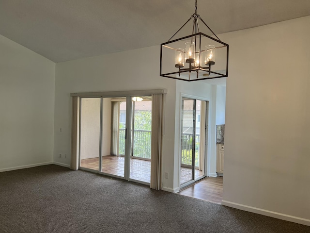 doorway to outside featuring carpet flooring and a chandelier