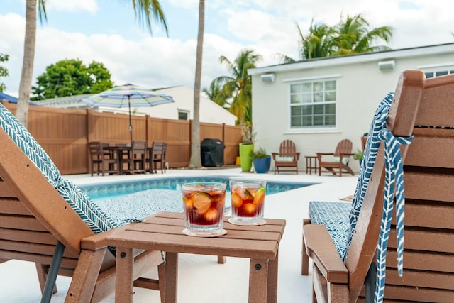 view of swimming pool featuring a patio and grilling area