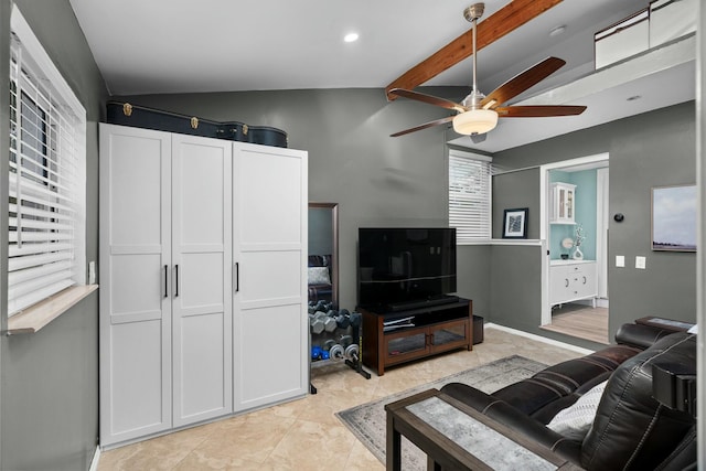 living room featuring vaulted ceiling with beams, ceiling fan, and a healthy amount of sunlight