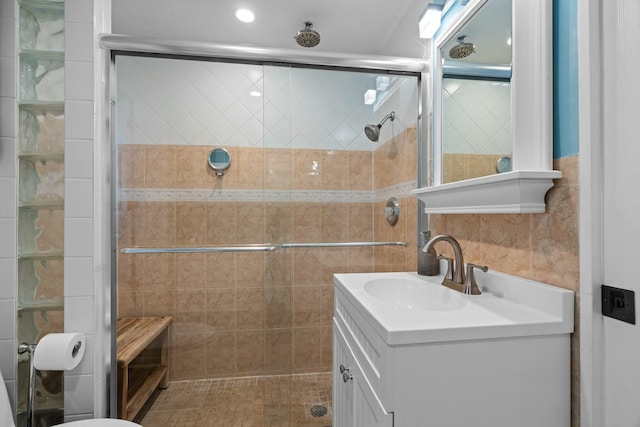 bathroom featuring vanity, an enclosed shower, and tile walls