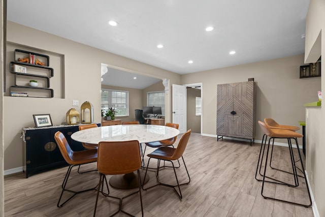 dining room with lofted ceiling and light hardwood / wood-style flooring