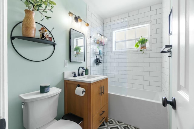 full bathroom featuring vanity, tiled shower / bath combo, and toilet