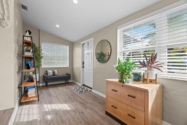 foyer entrance featuring vaulted ceiling and light hardwood / wood-style flooring