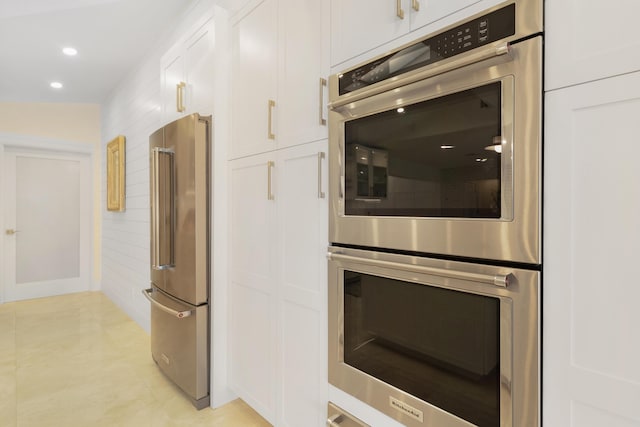 kitchen with white cabinetry, stainless steel appliances, and lofted ceiling