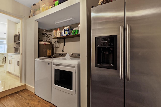 laundry area with hardwood / wood-style flooring, independent washer and dryer, and water heater