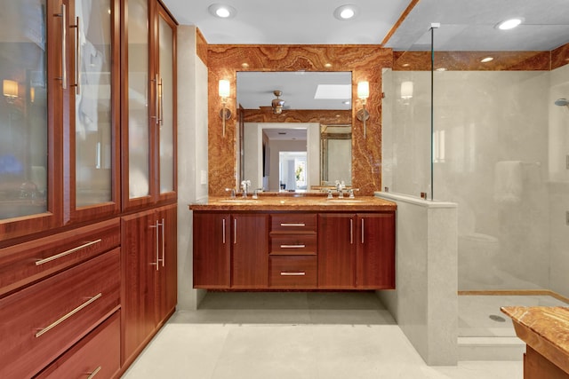 bathroom featuring ceiling fan, vanity, and walk in shower