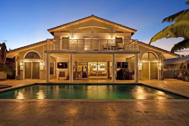 rear view of property with a patio area and a balcony