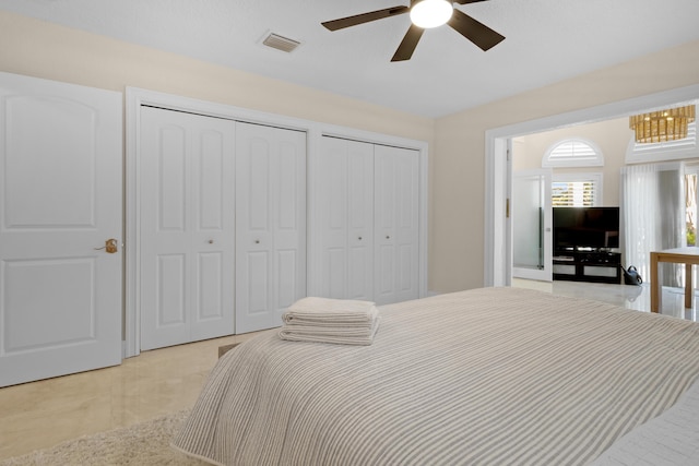 bedroom featuring ceiling fan and two closets