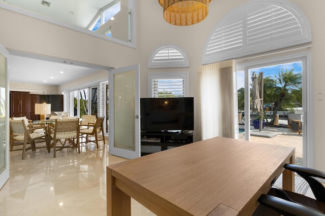 dining area with a towering ceiling