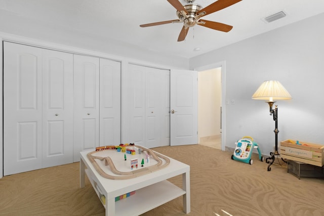 recreation room with light colored carpet and ceiling fan