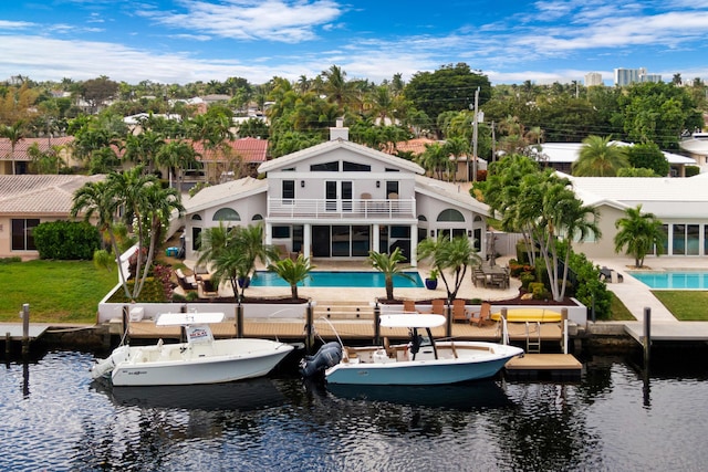 back of house featuring a balcony, a water view, and a patio