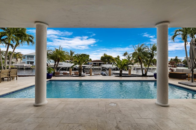 view of swimming pool featuring a water view and a patio