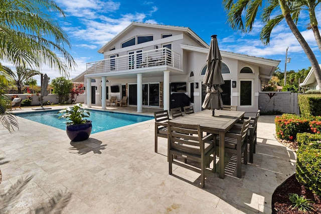 back of house featuring a patio, a balcony, and a fenced in pool