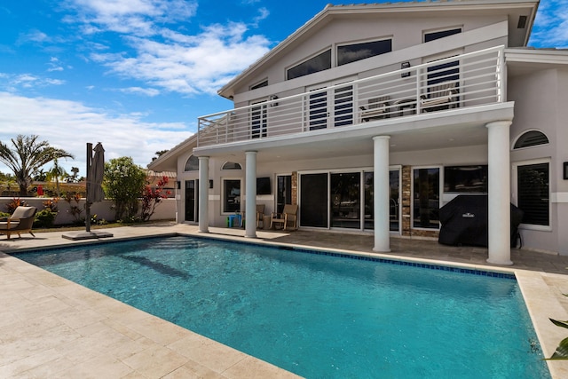 rear view of property featuring a balcony and a patio area