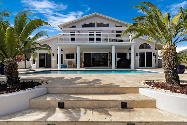 rear view of property with a patio and a balcony