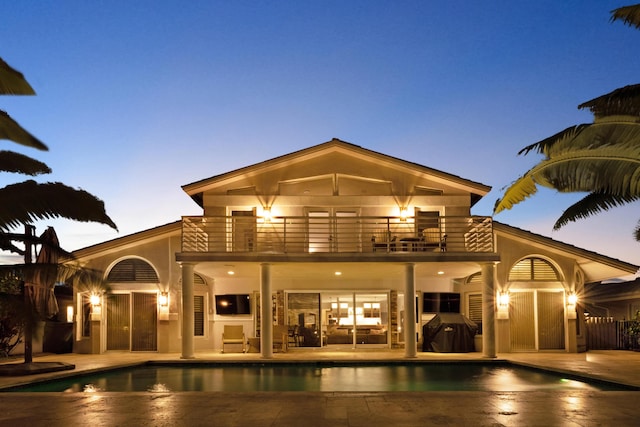 rear view of house with a balcony and a patio