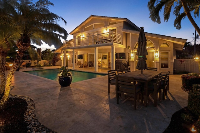 pool at dusk with a patio