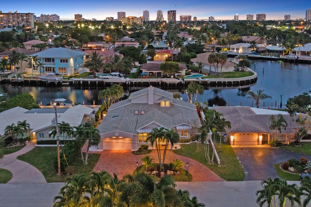 aerial view at dusk featuring a water view