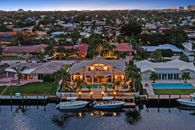 aerial view at dusk featuring a water view