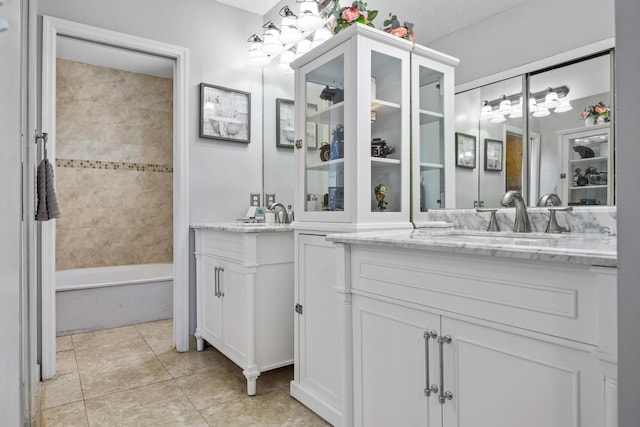 bathroom with tile patterned flooring, vanity, a bathtub, and a textured ceiling